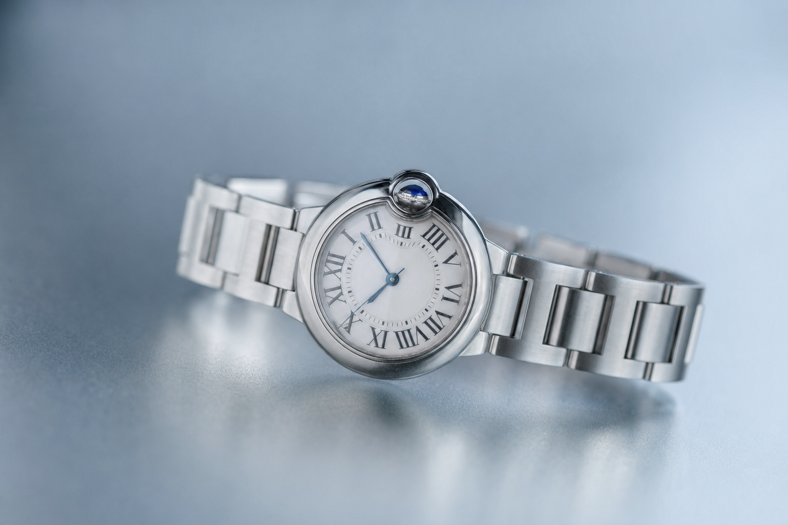 Authentic Cartier Ballon Bleu 33mm stainless steel watch on a white background, highlighting its iconic domed crystal and blue sapphire cabochon.