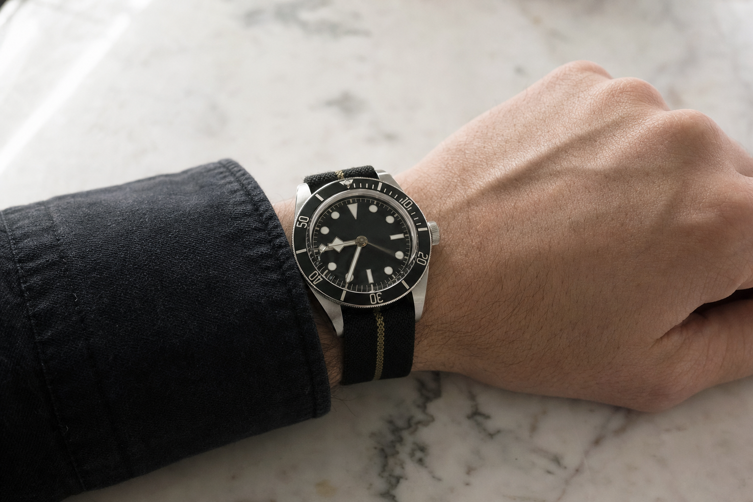 Tudor Black Bay 58 on a man's wrist, emphasizing its vintage aesthetic and versatile wearability