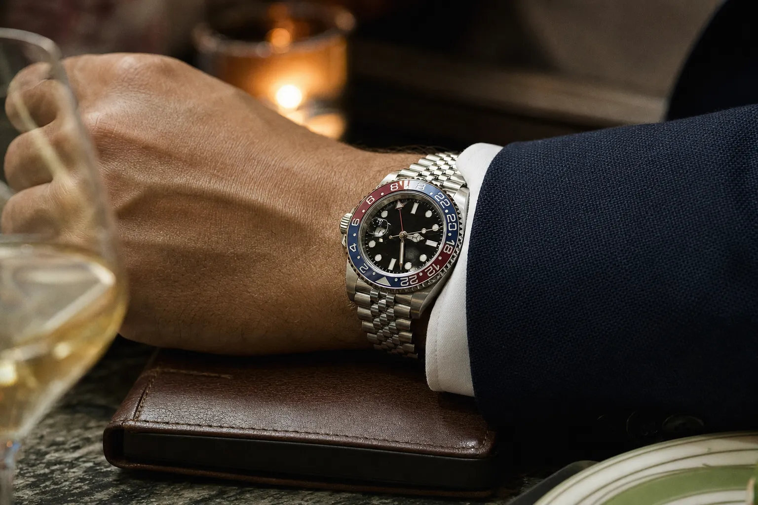 Rolex GMT-Master II Pepsi flyer movement watch on Jubilee bracelet beside leather travel passport