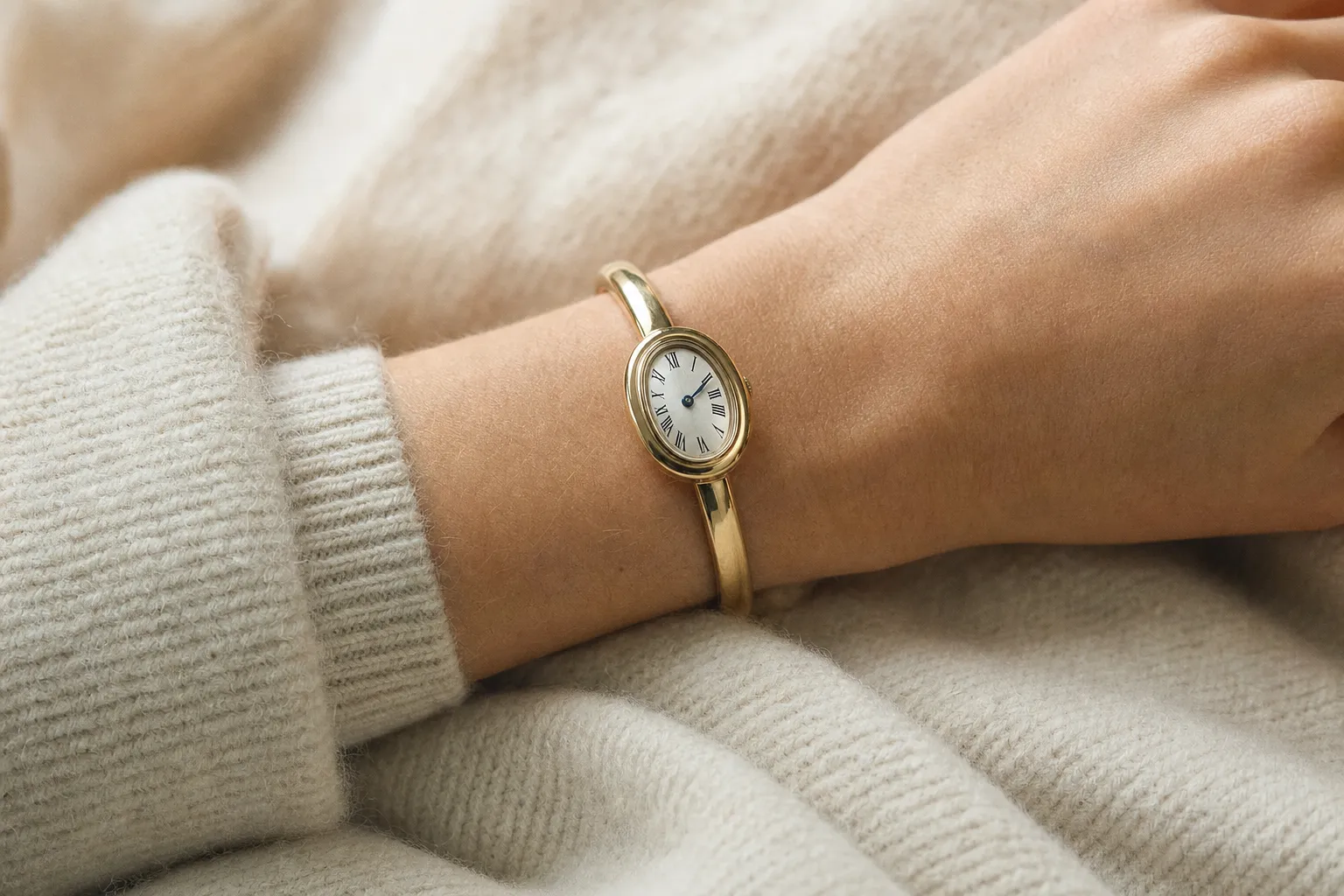 Cartier Baignoire Mini yellow gold bangle watch resting on an editorial display tray