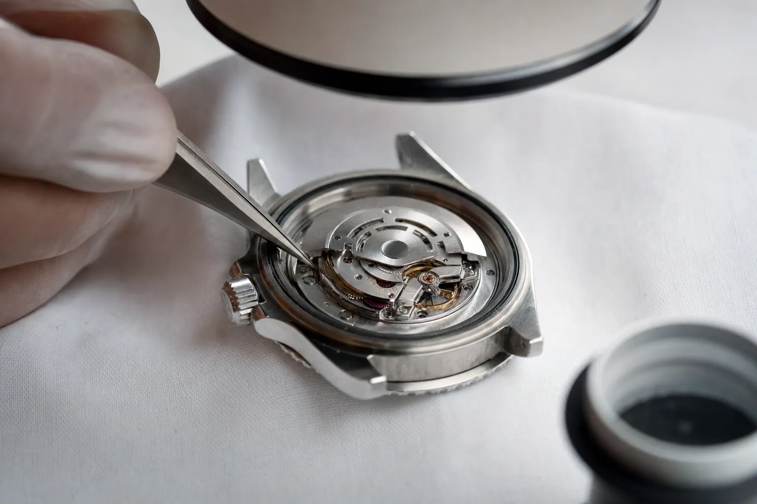 Watchmaker inspecting an opened luxury watch caseback movement under high-magnification microscope for superclone authentication