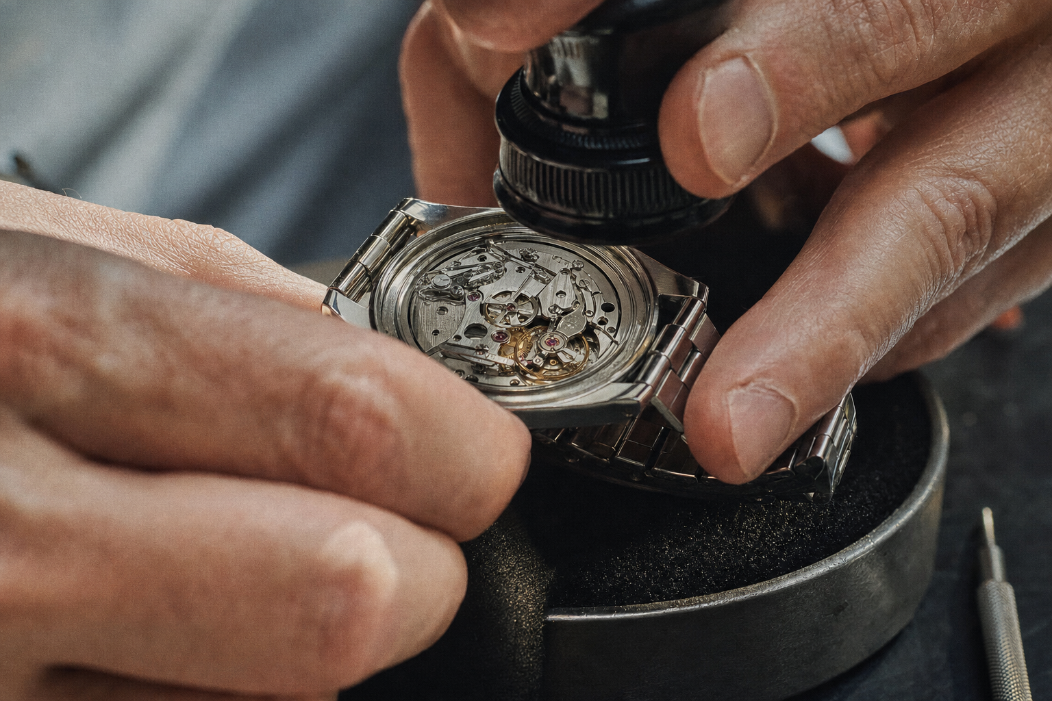 Watchmaker examining a luxury watch movement with a loupe, ensuring authentic internal components.
